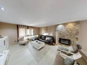 - un salon avec un canapé et une cheminée en pierre dans l'établissement Villa Mauricio Garden, 