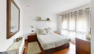 une chambre blanche avec un lit et un miroir dans l'établissement Villa Mauricio Garden, 