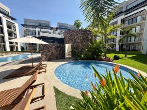 a swimming pool with two benches next to a building at Modern Luxury Residency at Altea-Sunset Pool View in Puerto Vallarta
