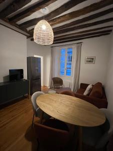 a living room with a table and a couch at L'Ecrin Bellifontain - Appartement Confort - Centre in Fontainebleau +11 photos