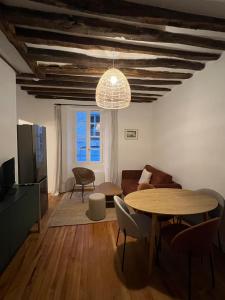a living room with a table and a couch at L'Ecrin Bellifontain - Appartement Confort - Centre in Fontainebleau
