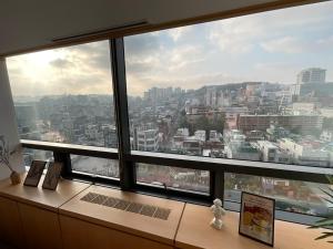 a view of a city from a large window at 18 Hongik Univ Best location city view in Seoul