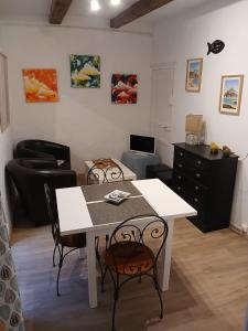 un salon avec une table et des chaises blanches dans l'établissement Granville hyper centre, à Granville