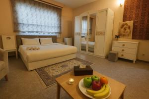 a bedroom with a bed and a table with a plate of fruit at البيت الايطالي - Italiano House in Baghdād