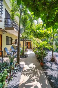 a courtyard with palm trees and a building at Tamarindo Sunshine in Tamarindo