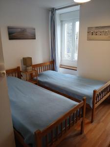 une chambre avec deux lits et une fenêtre dans l'établissement Granville hyper centre, à Granville