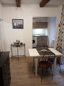 une cuisine avec une table et des chaises dans une pièce dans l'établissement Granville hyper centre, à Granville