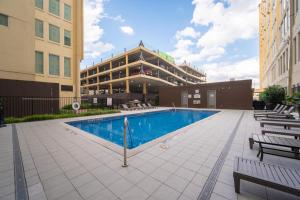 una piscina di fronte a un edificio con sedie di Retro Music Flat, 2BR, FREE Valet, Gym, Pool, Downtown Dallas a Dallas