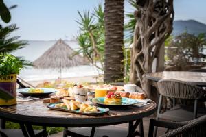 una mesa con platos de comida en la playa en Mare Hotel, en Savona