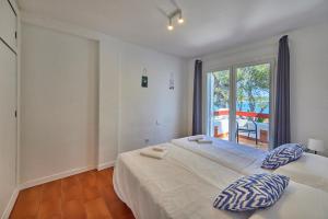 a bedroom with a large white bed and a window at Nura Houses Magaluf Apartment in Magaluf