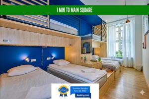 two beds in a room with a blue wall at Draggo House Rooms - Old Town in Kraków