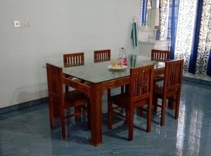a dining room table with chairs and a table and a table and chairsktop at Mridanga Homestay in Iritti