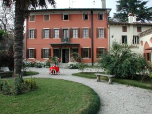 a large red building with a park in front of it at B&b Villa Bornancini in Cinto Caomaggiore
