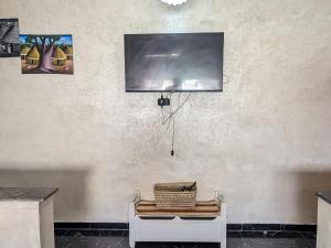 a room with a tv on a wall with a chair at Tayyurt Apartement city centre agadir in Agadir