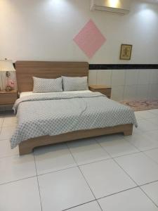 een slaapkamer met een groot bed met een roze briefje aan de muur bij إستراحة الريف in Kalbā