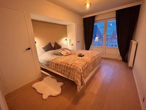 ein Schlafzimmer mit einem Bett und einem großen Fenster in der Unterkunft Zoute74 - Luxury Penthouse in Knokke-Heist