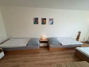 a bedroom with two beds and a table with a lamp at Apartmán Kocourkov in Jáchymov