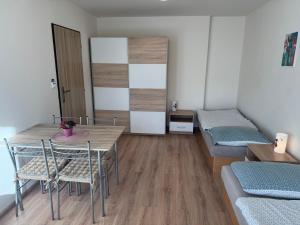 a room with a bed and a table and chairs at Apartmán Kocourkov in Jáchymov