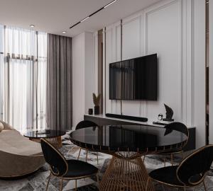 een woonkamer met een tv en een tafel en stoelen bij Khatai Deluxe Hotel in Baku