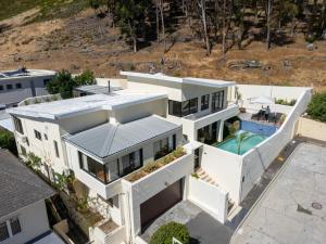 an aerial view of a white house with a swimming pool at Sun & Fun In Fresnaye - Family Summer in Cape Town