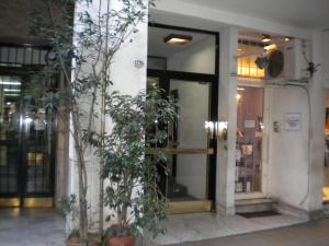 a building with two trees in front of a door at Recoleta Apartamento in Buenos Aires