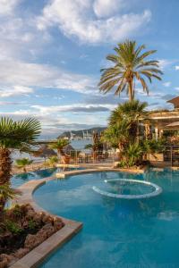Una gran piscina con palmeras en un complejo turístico. en Mare Hotel, en Savona