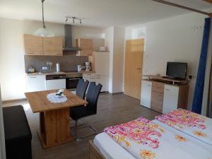 a room with two beds and a table and a kitchen at Nagelehof 3 in Ainet