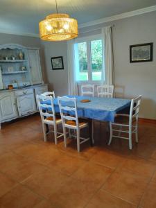 a dining room with a blue table and chairs at Maison chaleureuse in Mézos +4 photos