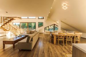 a large living room with a table and a dining room at Musala Hotel in Borovets