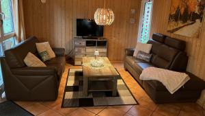 a living room with two couches and a tv at Ferienhaus Sonnenuntergang Nähe Freizeitpark Schloss Dankern Dankernsee in Düne