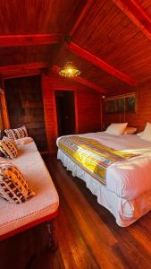 a bedroom with two beds and a chandelier at Barraco Lodge in Puelo