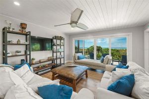 a living room with white furniture and a large window at A Tide that Binds Us By Beachside Management in Siesta Key