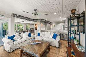 a living room with two white couches and a table at A Tide that Binds Us By Beachside Management in Siesta Key
