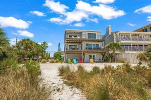 a large house on a beach with palm trees at A Tide that Binds Us By Beachside Management in Siesta Key
