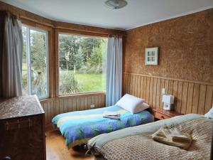 Ένα ή περισσότερα κρεβάτια σε δωμάτιο στο Cabaña Bahía Huillín, Cascadas, lago Llanquihue