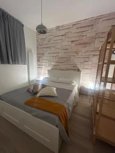 ETNA HOUSE LUXURY con giardino e vasca idromassaggio في لينغواغلوسا: غرفة نوم بسرير كبير وجدار حجري