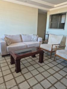a living room with a couch and a coffee table at Apartamento Cancún - Praia de Intermares, a 100 metros da Praia in Cabedelo