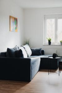 ein Wohnzimmer mit einer schwarzen Couch und einem Tisch in der Unterkunft Modernes Penthouse mit Panorama im Herzen von Villingen in Villingen-Schwenningen + 42 Fotos