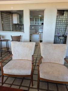 two chairs sitting on top of a porch at Apartamento Cancún - Praia de Intermares, a 100 metros da Praia in Cabedelo