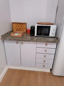 un bancone della cucina con forno a microonde sopra di Candela con amor a Punta Umbría Altre 2 foto