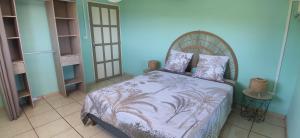 a bedroom with a bed and a blue wall at Fleur de Canne in Saint-Pierre