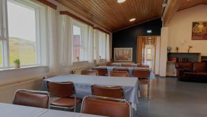 a room with a row of tables and chairs at Helgafell Hostel in Djúpivogur
