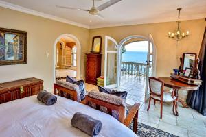 a bedroom with a bed and a balcony with the ocean at Villa Bel Fiori - 4 Bedroom Villa in Ballito +52 photos