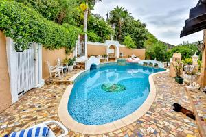 a swimming pool in a yard with a patio at Villa Bel Fiori - 4 Bedroom Villa in Ballito