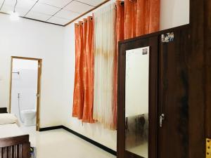 una habitación con una puerta, una ventana y un espejo en Jayamaha Guest, en Bopitiya