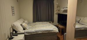 a small bedroom with a bed and a television at Lyngen Ski Apartment in Lyngen
