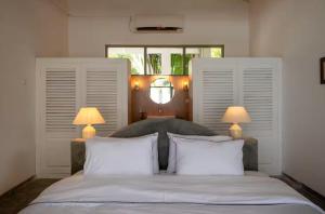 une chambre avec un grand lit avec deux lampes dans l'établissement Villa Elise, à Sinimodera