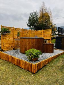 a garden with a wooden fence and two potted plants at ORAWSKA CHATA - domek z balią pod Babią Górą in Zubrzyca Górna