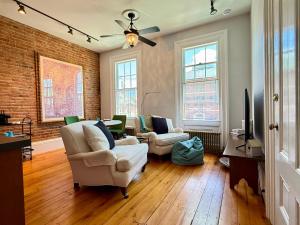 a living room with two chairs and a ceiling fan at Townhouse in Portsmouth Downtown Historic District in Portsmouth