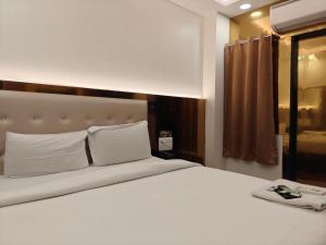 a bedroom with a large bed with white sheets and pillows at Hotel The Grend Gauranga Just a min walk from New Delhi Railway Station - Paharganj in Jāmb